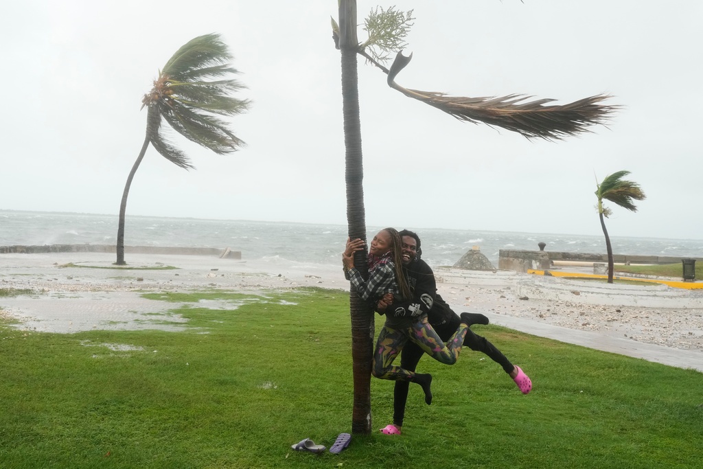 A couple jokes around Tuesday on the coast in Kingston, Jamaica, as Hurricane Melissa approaches